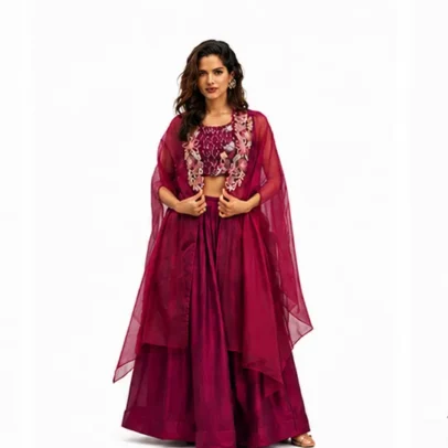 Beautiful woman wearing a maroon embroidered lehenga set with a stylish cape-style dupatta, perfect for weddings, festive occasions, and party wear.